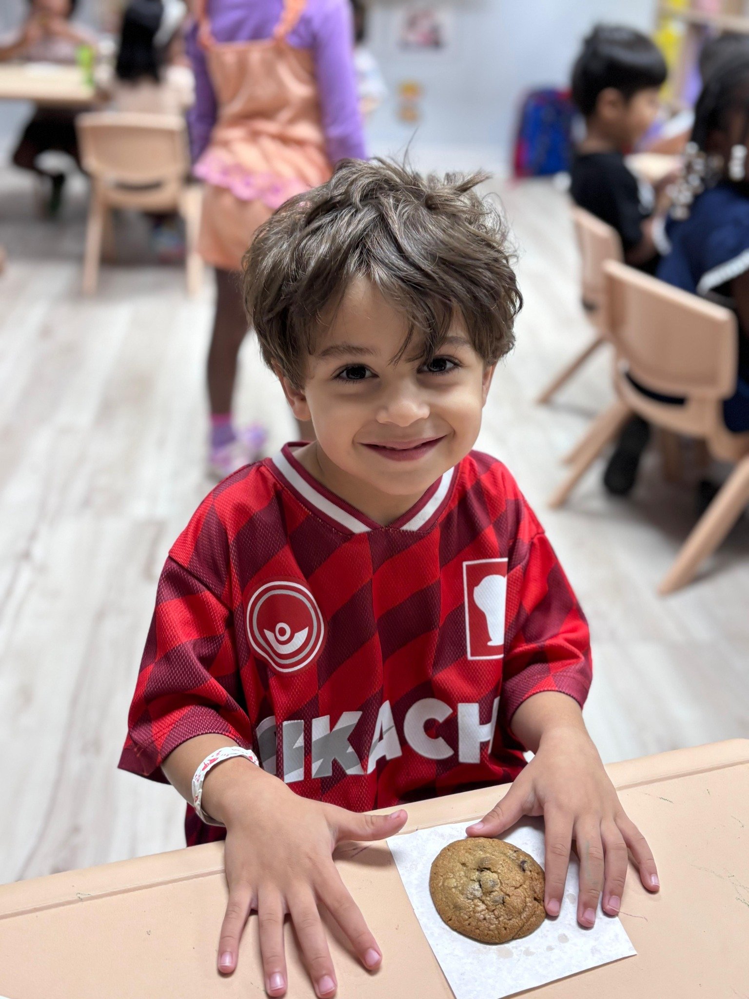 Child smiling after a supervised hands-on baking activity at Starz R Us
