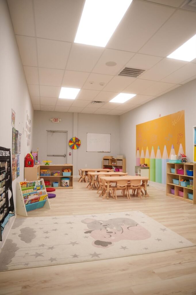 Bright preschool classroom with learning tables, books and activity areas